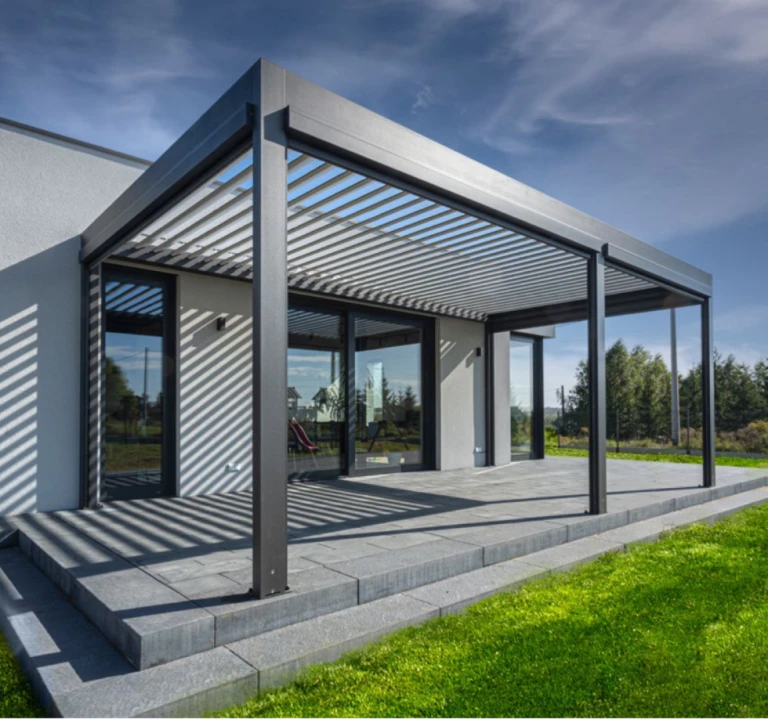 Eine moderne, bioklimatische Pergola mit schwenkbaren Lamellen auf der Terrasse eines Einfamilienhauses