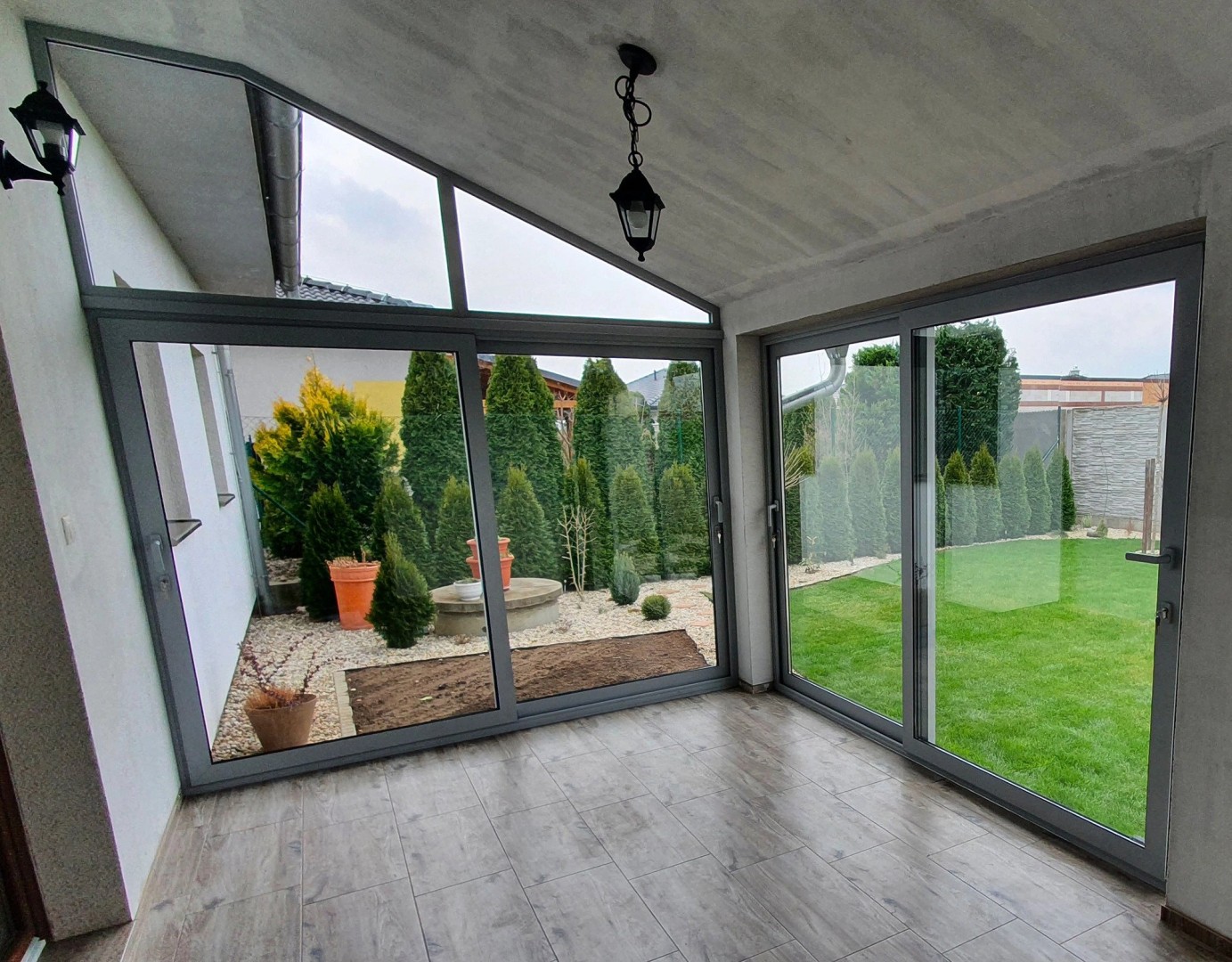 Moderne Terrassenverglasung mit Schiebetüren und Blick in den Garten