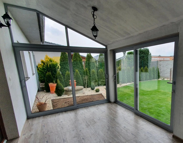Moderne Terrassenverglasung mit Schiebetüren und Blick in den Garten