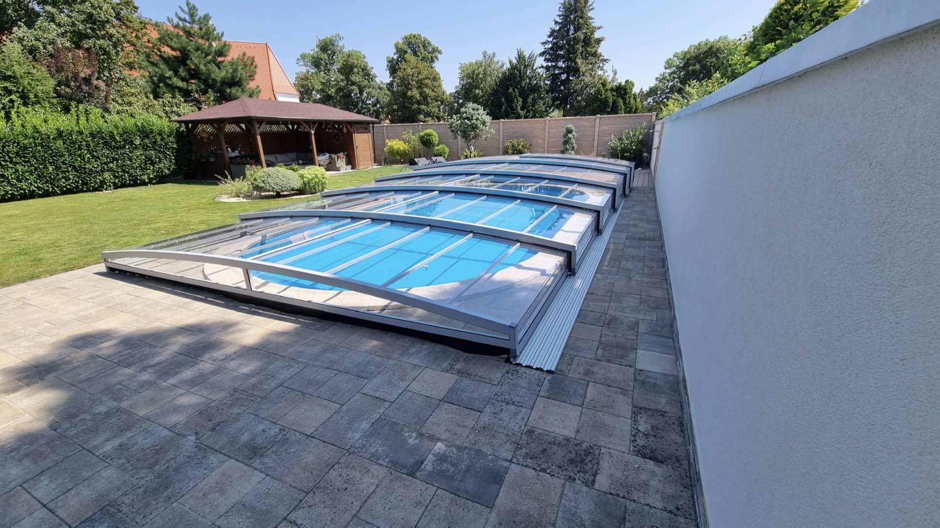 Moderne, niedrige PREMIER-Schwimmbadüberdachung mit transparenter Verkleidung im Garten in Modra