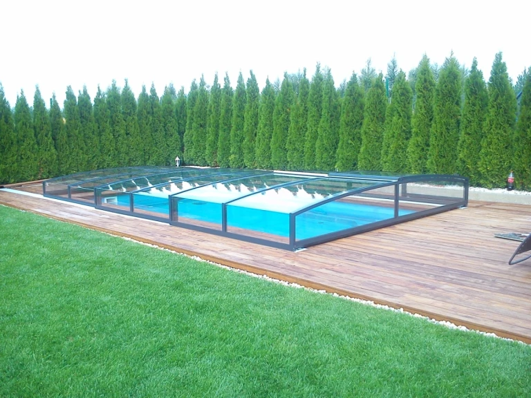 Moderne, niedrige STAR-Schwimmbadüberdachung auf der Terrasse mit Blick in den Garten