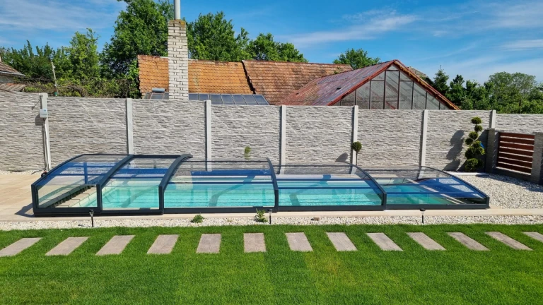 Moderne, niedrige Schwimmbadüberdachung mit anthrazitfarbener Konstruktion im Garten