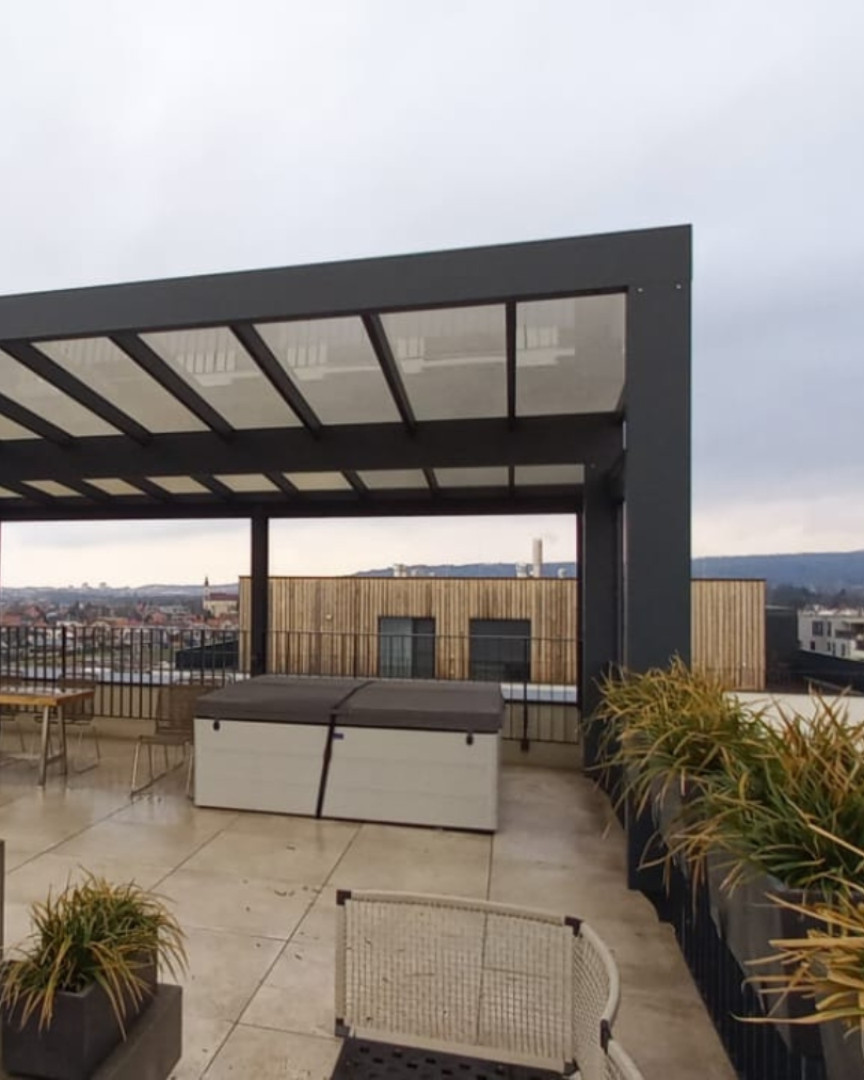 Eine moderne Aluminium-Pergola auf der Dachterrasse mit Blick auf die Stadt und einem Whirlpool