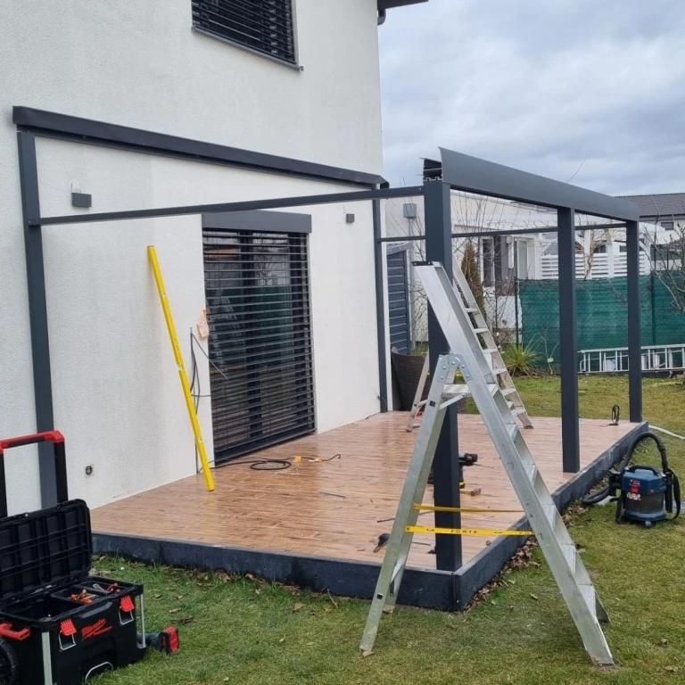 Montage einer Aluminiumkonstruktion für einen Wintergarten auf der Terrasse eines Einfamilienhauses.