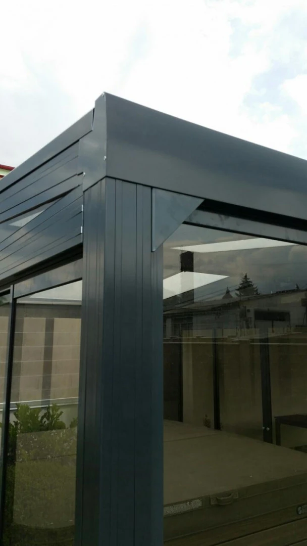 Detailansicht der oberen Ecke und der Verglasung einer dunklen Aluminium-Pergola