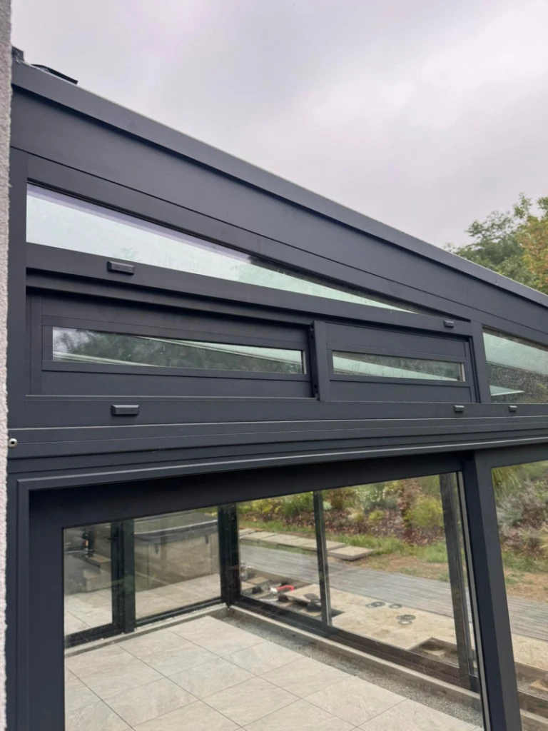 Detailansicht einer dunkel lackierten Aluminiumkonstruktion mit Verglasung im Wintergarten