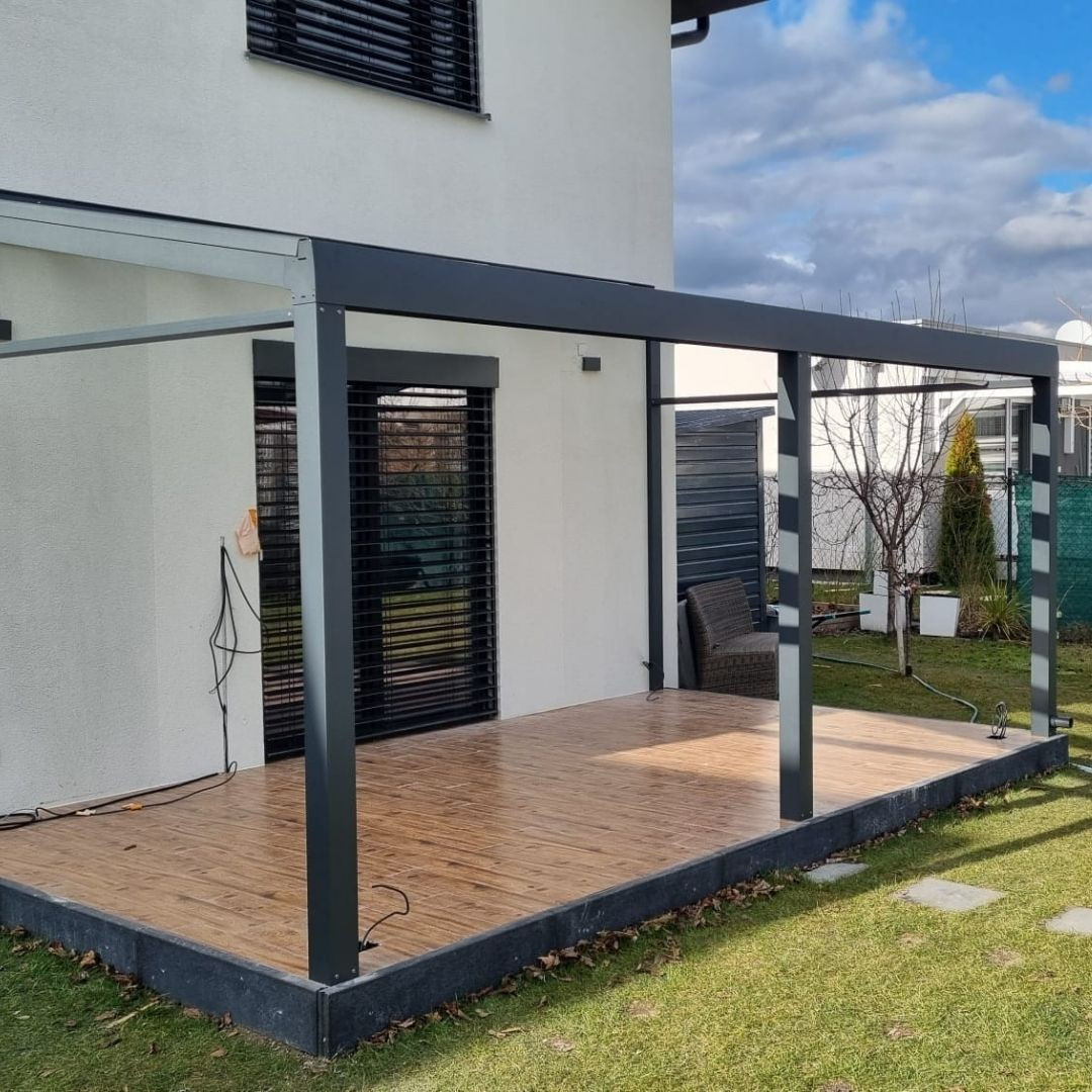 Bau eines Wintergartens aus Aluminium auf der Holzterrasse eines Einfamilienhauses.