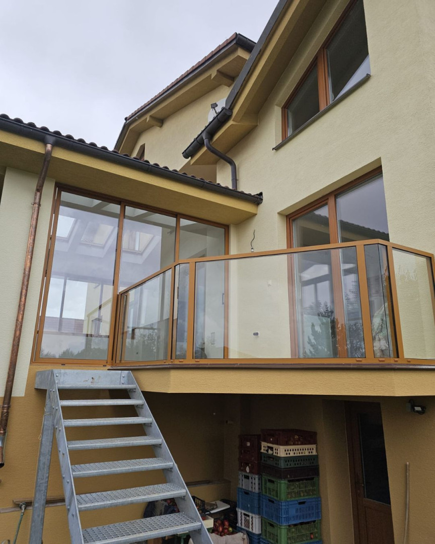 Moderne Terrassenverglasung mit Aluminiumgeländer an einem Einfamilienhaus