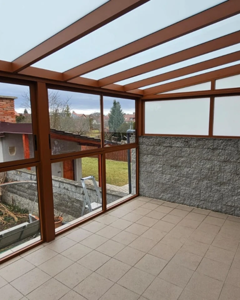 Verglaste Aluminium-Pergola mit braunem Rahmen und Blick in den Garten