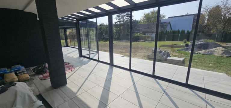Ein moderner, verglaster Wintergarten mit Blick auf den Innenhof während der Bauphase